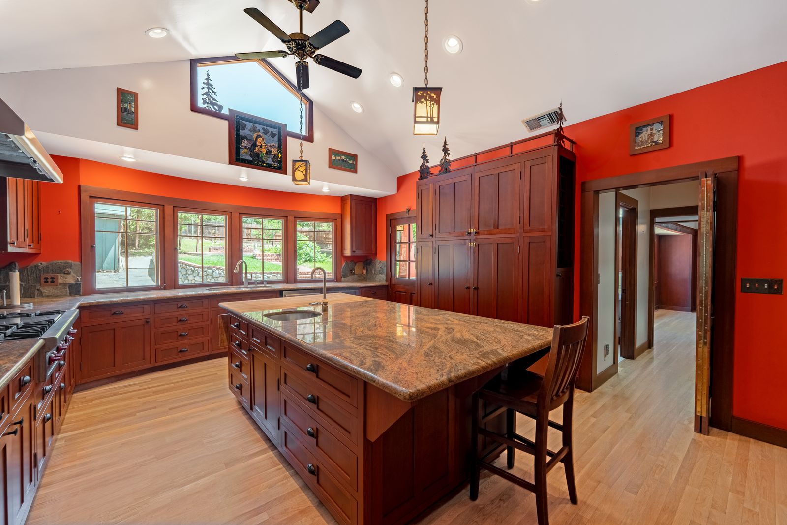 Kitchen with red walls, wood cabinets and a granite island