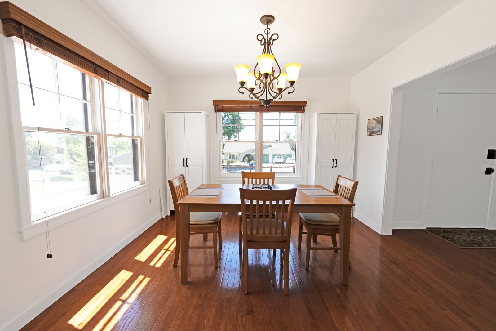 Bright dining room with a wood table, chandelier and hardwood floors