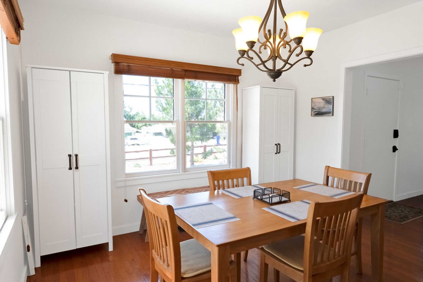 Dining table and white cabinets beside a double-hung window